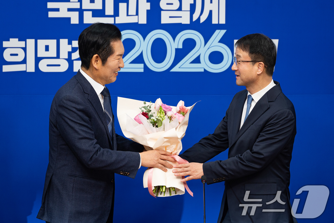 (서울=뉴스1) 유승관 기자 = 정청래 더불어민주당 대표가 12일 서울 여의도 국회에서 열린 최고위원회의에 앞서 한병도 신임 원내대표에게 꽃다발을 건네고 있다. 2026.1.12/ …