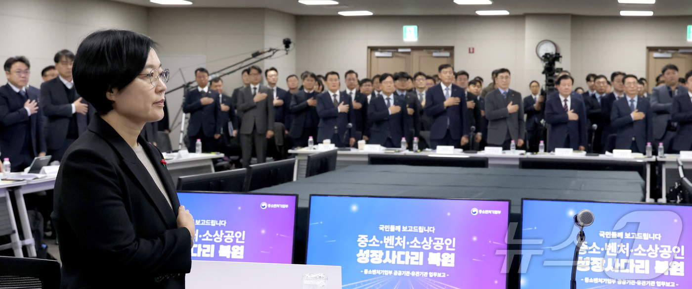 (세종=뉴스1) 김기남 기자 = 한성숙 중소벤처기업부 장관이 12일 세종시 정부컨벤션센터에서 열린 산하기관 업무보고에 앞서 기관장들과 국민의례를 하고 있다. 2026.1.12/뉴스 …