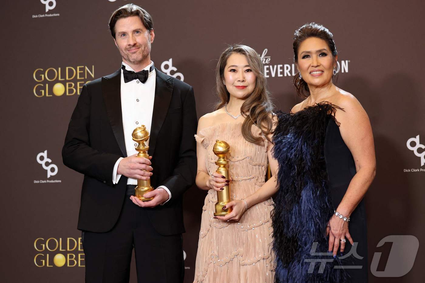 본문 이미지 - 11일(현지시각) 미국 캘리포니아주 베벌리힐스 베벌리힐턴 호텔에서 열린 제83회 골든글로브 시상식에서 장편 애니메이션상을 수상한 넷플릭스 애니메이션 영화 ‘케이팝 데몬 헌터스’의 메기강 감독(가운데)이 트로피를 들고 포즈를 취하고 있다. ⓒ AFP=뉴스1 ⓒ News1 박세연 기자