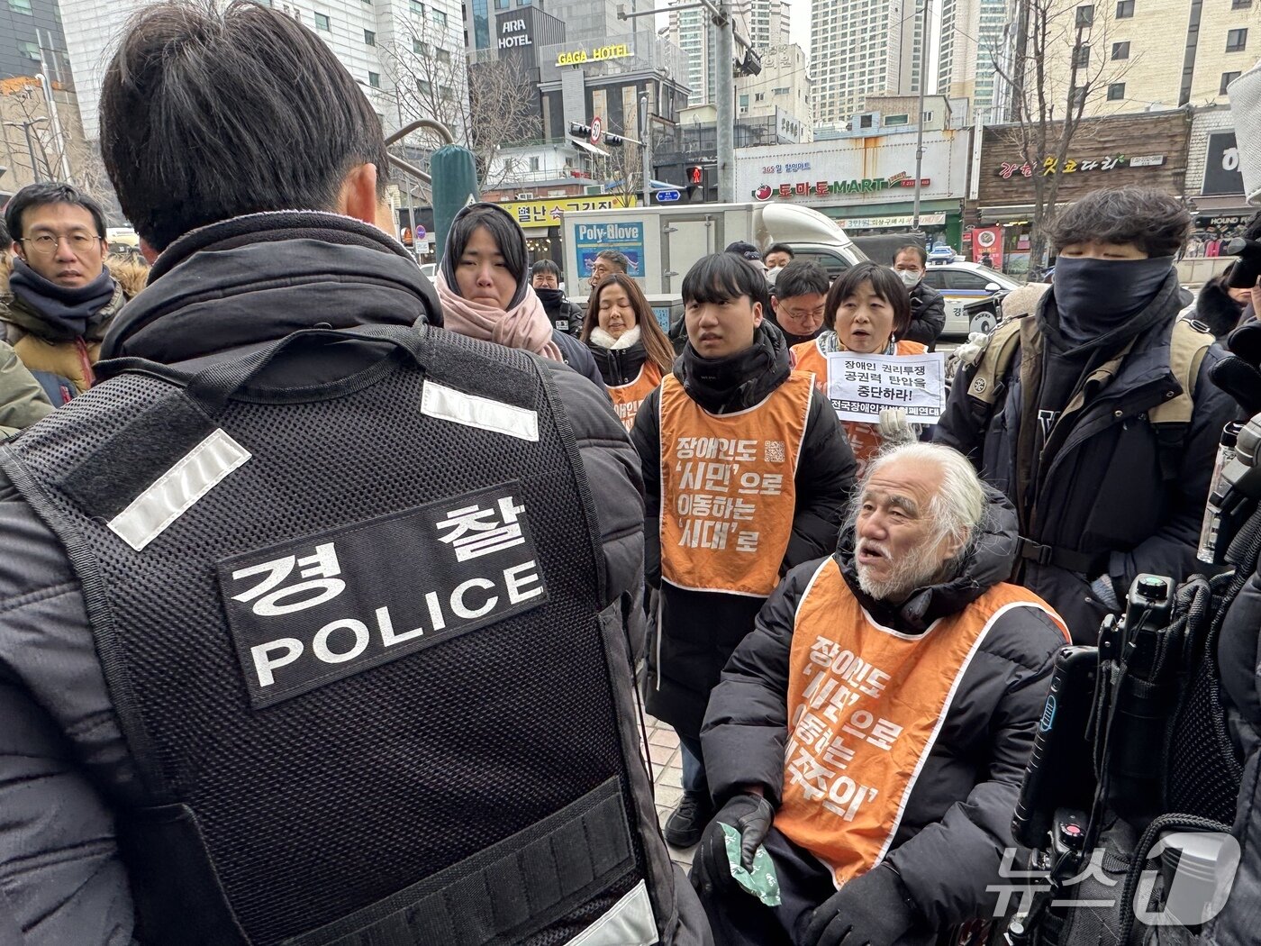 본문 이미지 - 혜화경찰서 경내로 진입을 시도하는 전장연 활동가들. 2026.1.12/뉴스1 ⓒ News1 권준언 기자