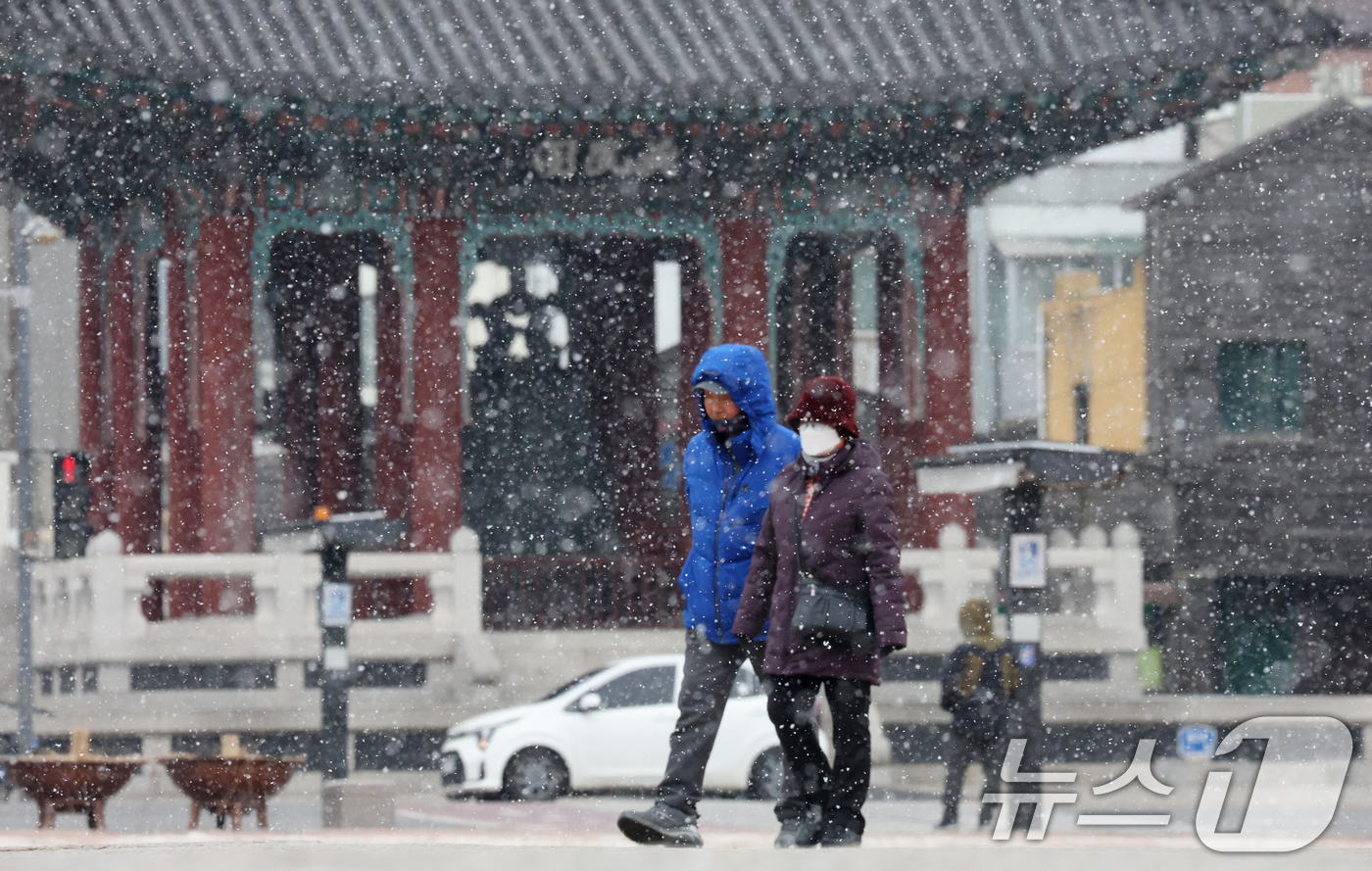 (수원=뉴스1) 김영운 기자 = 중부지방을 중심으로 눈이 내린 12일 경기 수원시 팔달구 화성행궁에서 시민들이 눈을 맞으며 걸어가고 있다. 2026.1.12/뉴스1