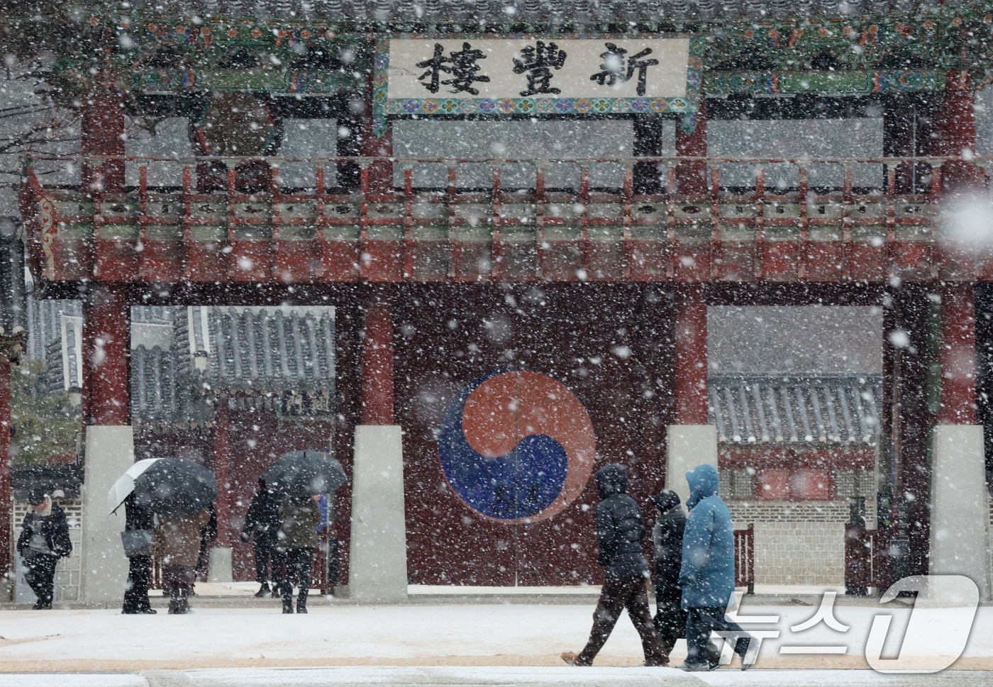 (수원=뉴스1) 김영운 기자 = 중부지방을 중심으로 눈이 내린 12일 경기 수원시 팔달구 화성행궁에서 시민들이 눈을 맞으며 걸어가고 있다. 2026.1.12/뉴스1