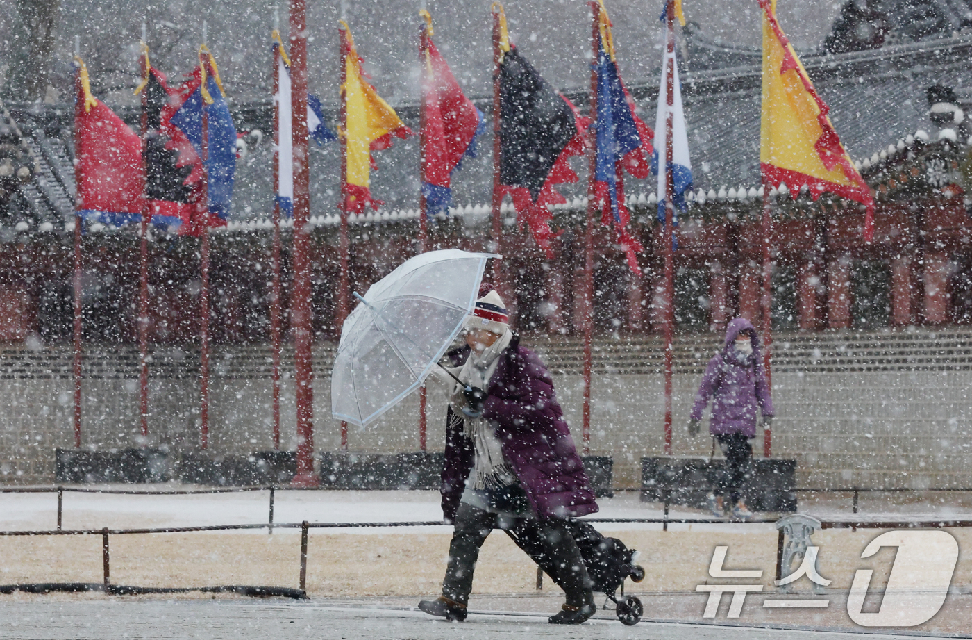 (수원=뉴스1) 김영운 기자 = 중부지방을 중심으로 눈이 내린 12일 경기 수원시 팔달구 화성행궁에서 시민들이 눈을 맞으며 걸어가고 있다. 2026.1.12/뉴스1