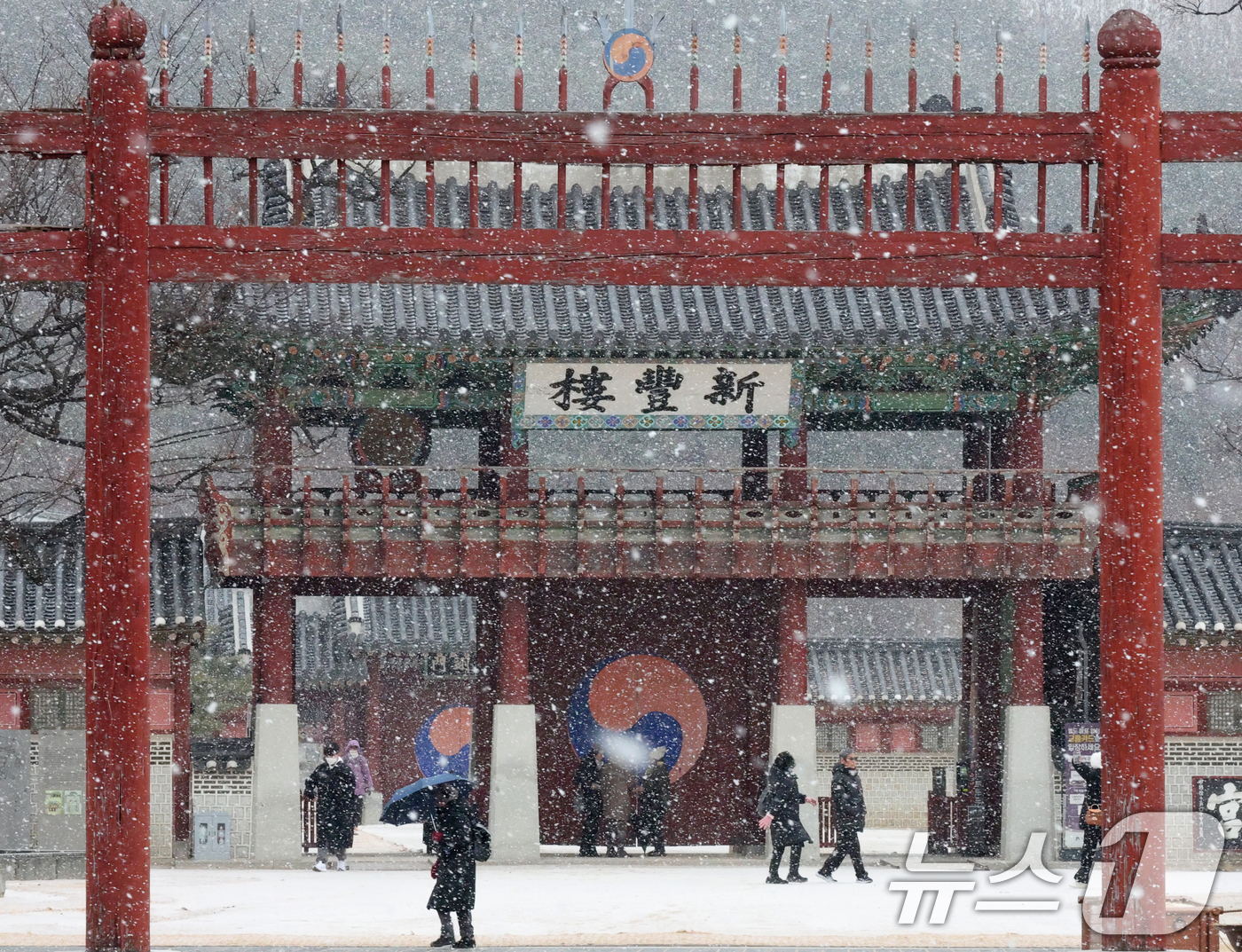 (수원=뉴스1) 김영운 기자 = 중부지방을 중심으로 눈이 내린 12일 경기 수원시 팔달구 화성행궁에서 시민들이 눈을 맞으며 걸어가고 있다. 2026.1.12/뉴스1