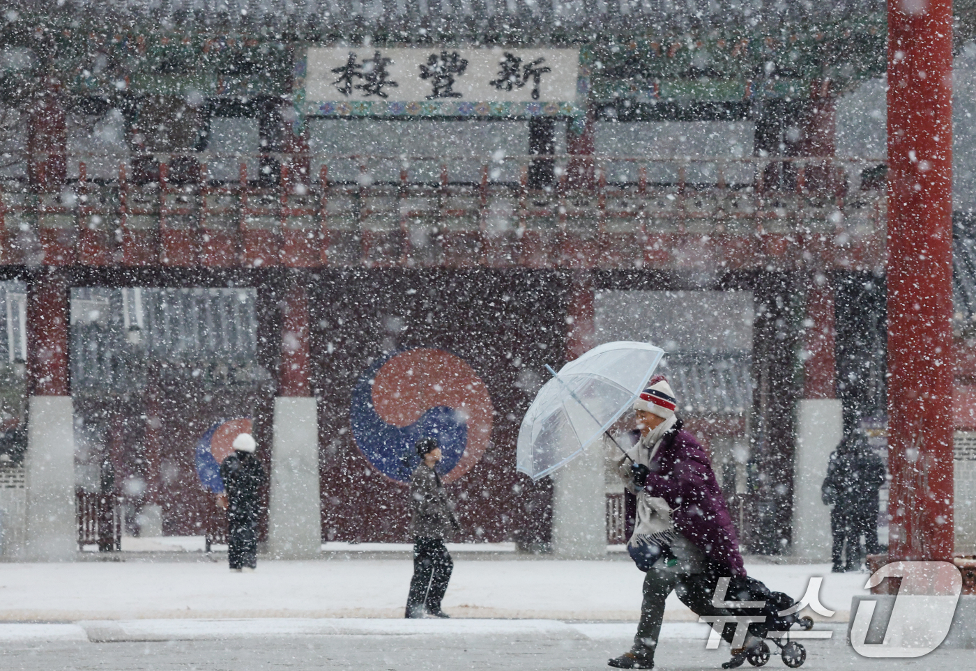 (수원=뉴스1) 김영운 기자 = 중부지방을 중심으로 눈이 내린 12일 경기 수원시 팔달구 화성행궁에서 시민들이 눈을 맞으며 걸어가고 있다. 2026.1.12/뉴스1