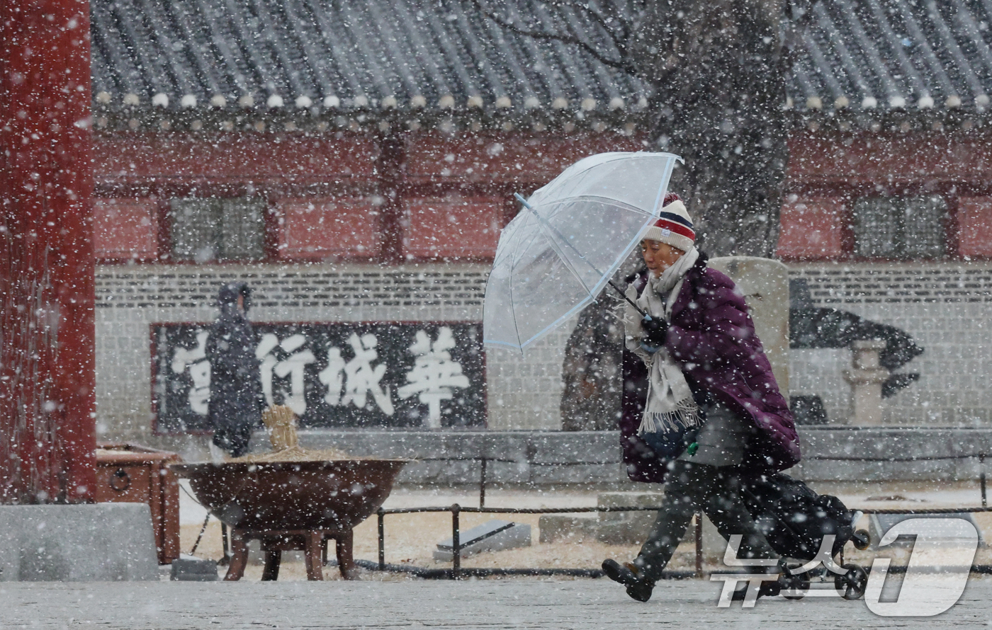 (수원=뉴스1) 김영운 기자 = 중부지방을 중심으로 눈이 내린 12일 경기 수원시 팔달구 화성행궁에서 시민들이 눈을 맞으며 걸어가고 있다. 2026.1.12/뉴스1