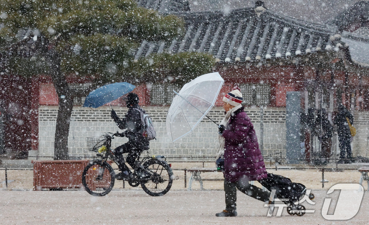 (수원=뉴스1) 김영운 기자 = 중부지방을 중심으로 눈이 내린 12일 경기 수원시 팔달구 화성행궁에서 시민들이 눈을 맞으며 걸어가고 있다. 2026.1.12/뉴스1