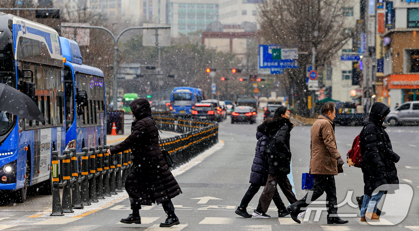 (서울=뉴스1) 이호윤 기자 = 눈이 내리는 12일 서울 세종대로사거리에서 시민들이 발걸음을 옮기고 있다. 2026.1.12/뉴스1
