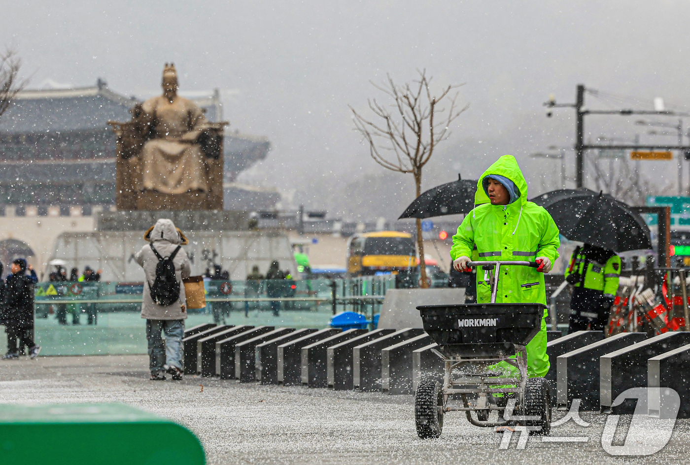 (서울=뉴스1) 이호윤 기자 = 눈이 내리는 12일 서울 광화문광장에서 작업자들이 염화칼슘을 뿌리고 있다. 2026.1.12/뉴스1
