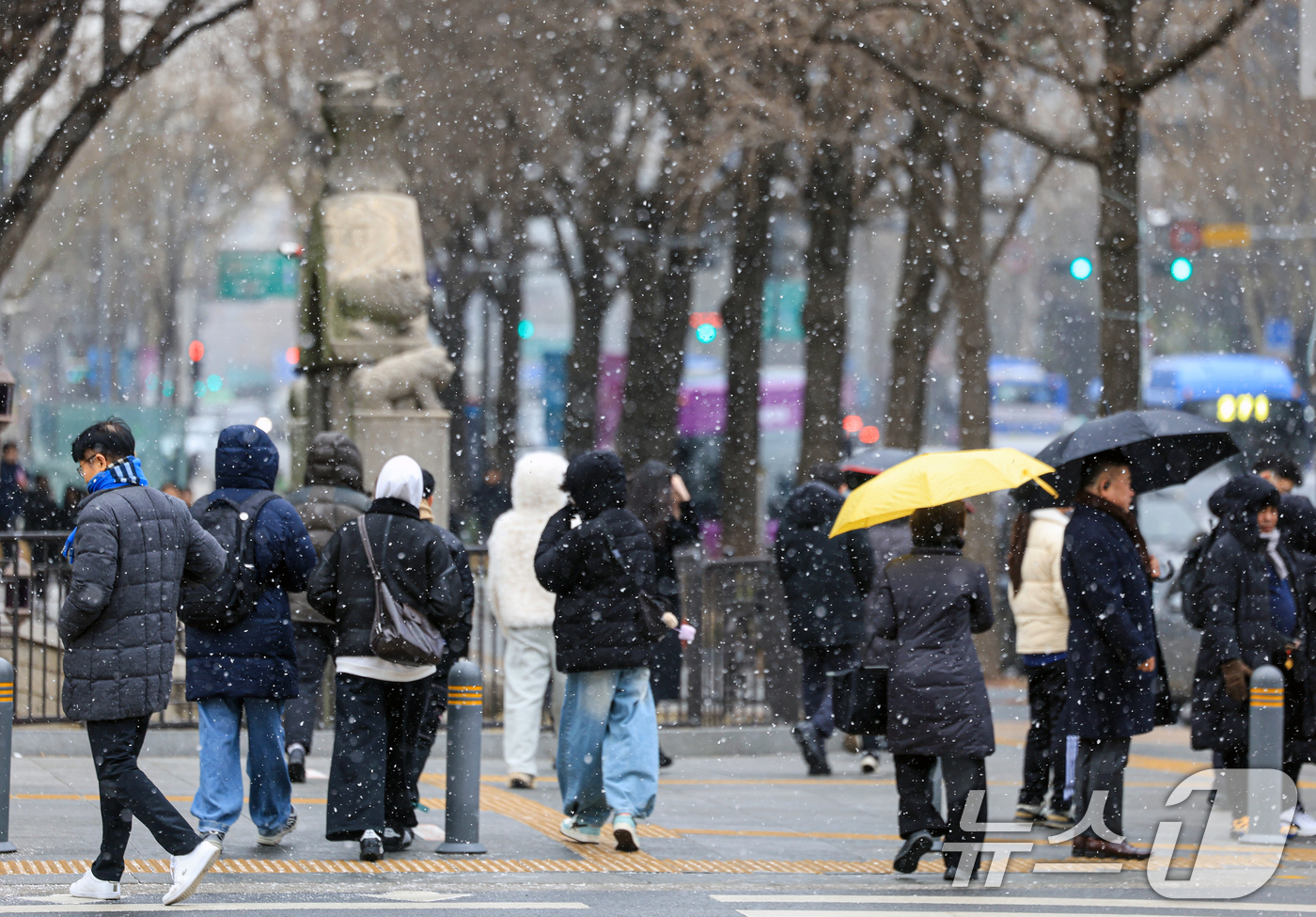 (서울=뉴스1) 이호윤 기자 = 눈이 내리는 12일 서울 세종대로사거리에서 시민들이 발걸음을 옮기고 있다. 2026.1.12/뉴스1