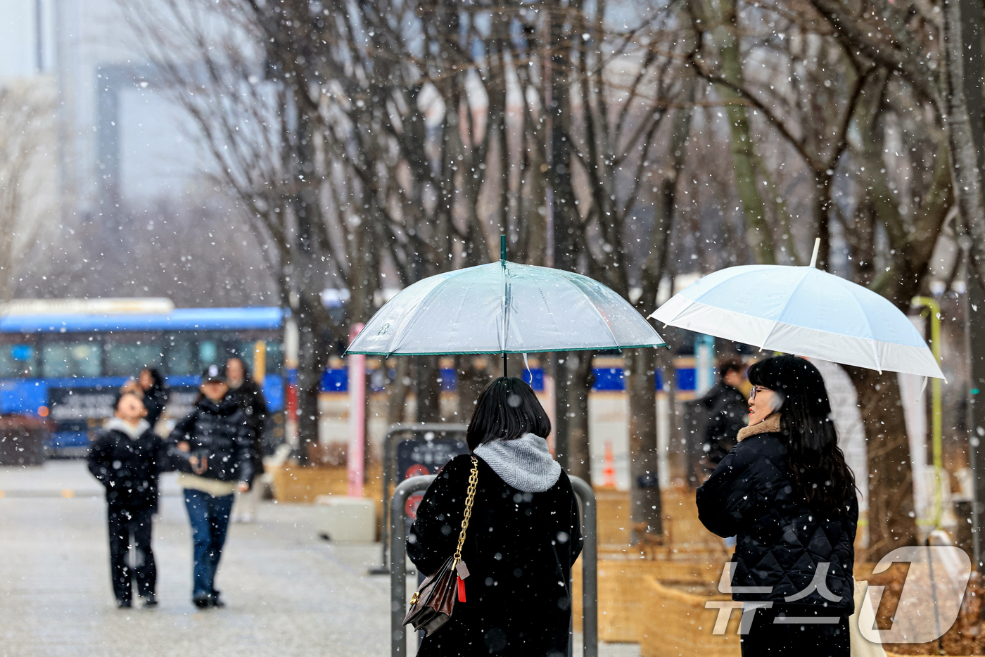 (서울=뉴스1) 이호윤 기자 = 눈이 내리는 12일 서울 광화문광장에서 시민들이 발걸음을 옮기고 있다. 2026.1.12/뉴스1
