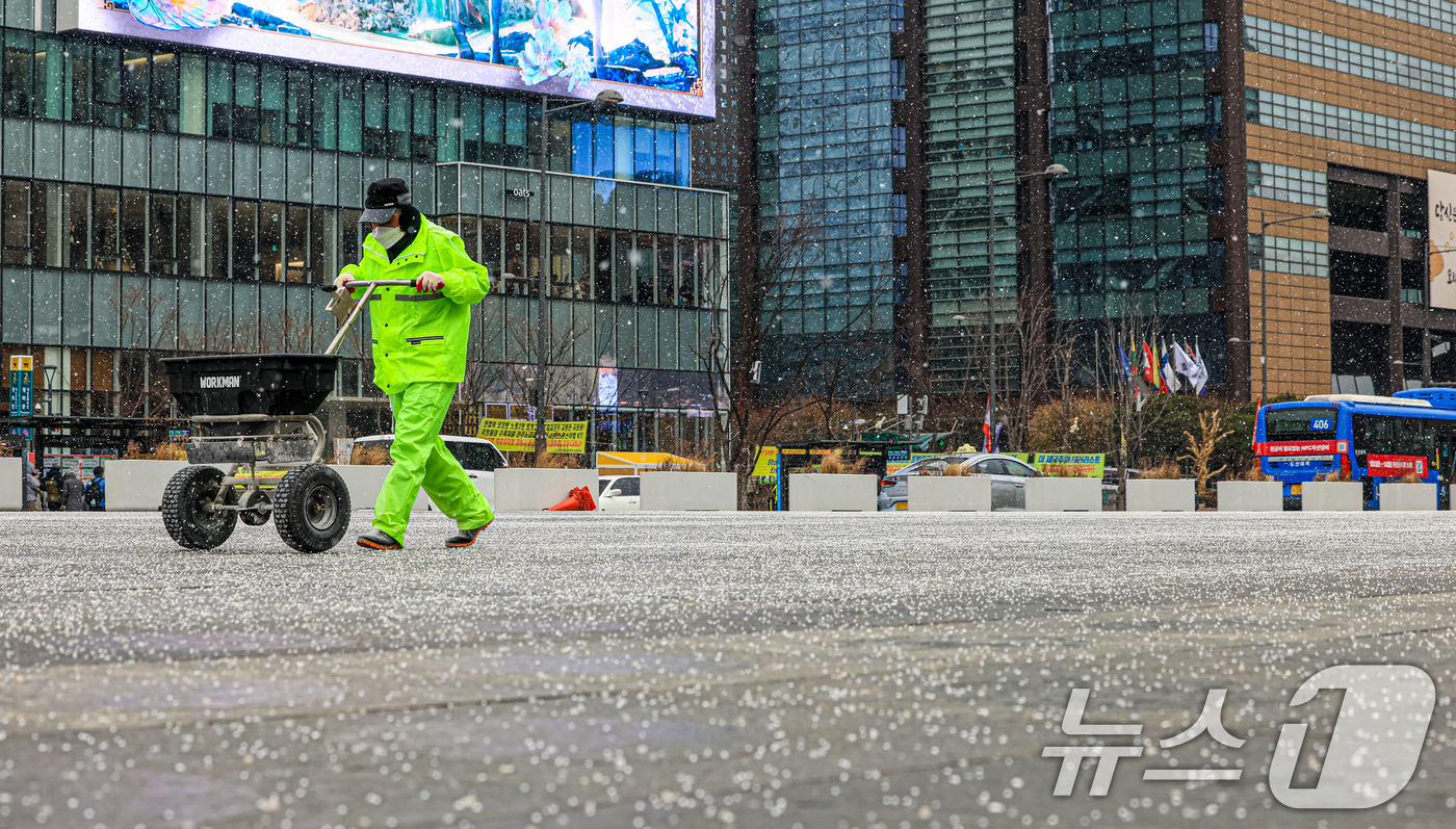 (서울=뉴스1) 이호윤 기자 = 눈이 내리는 12일 서울 광화문광장에서 작업자들이 염화칼슘을 뿌리고 있다. 2026.1.12/뉴스1
