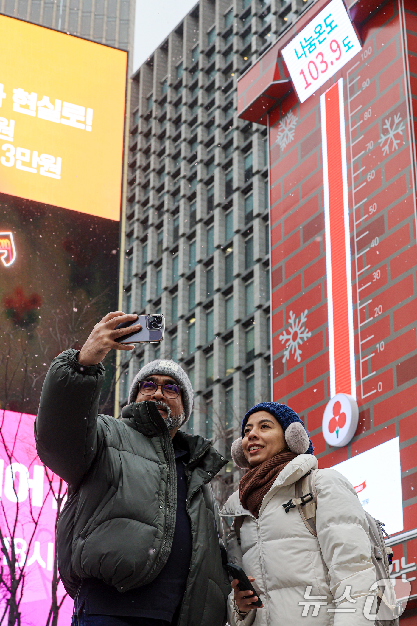 (서울=뉴스1) 이호윤 기자 = 12일 서울 종로구 광화문광장에서 외국인 관광객들이 사랑의 온도탑을 배경으로 사진을 찍고 있다.이날 사랑의열매 사회복지공동모금회는 ‘희망 2026 …