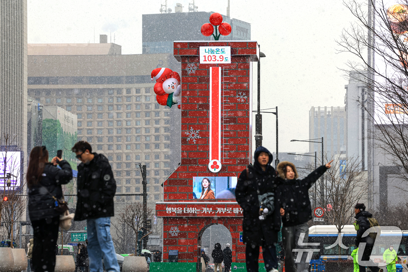 (서울=뉴스1) 이호윤 기자 = 12일 서울 종로구 광화문광장에서 외국인 관광객들이 사랑의 온도탑을 배경으로 사진을 찍고 있다.이날 사랑의열매 사회복지공동모금회는 ‘희망 2026 …