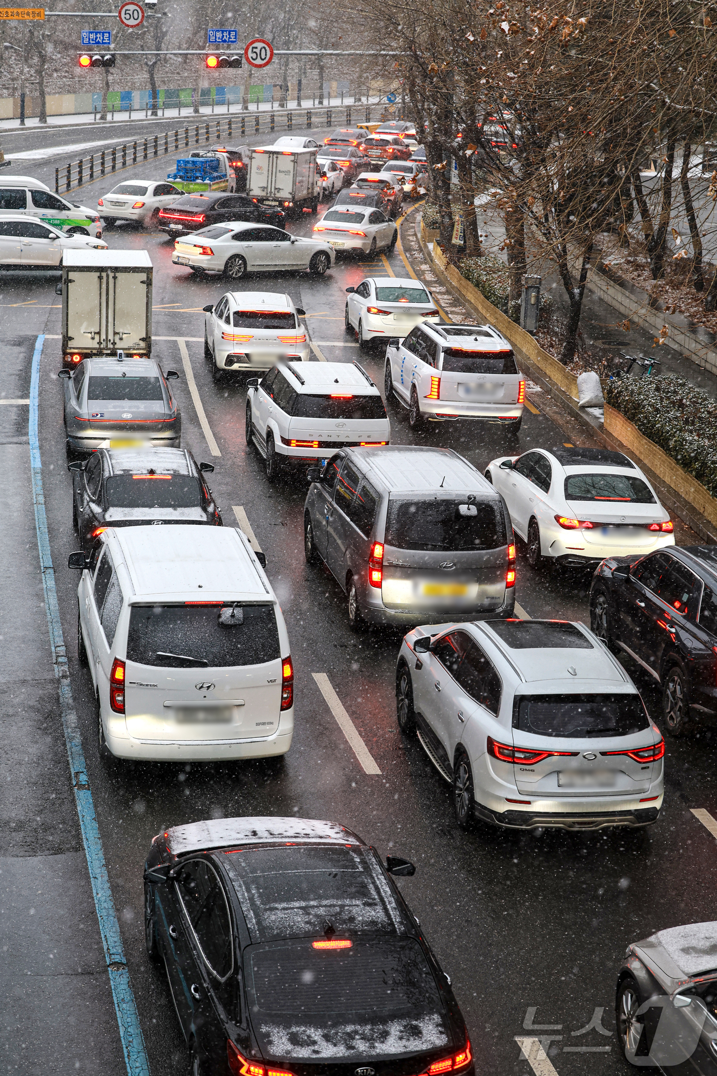 (서울=뉴스1) 이호윤 기자 = 눈이 내리는 12일 서울 마포구 인근 도로가 정체되고 있다. 2026.1.12/뉴스1