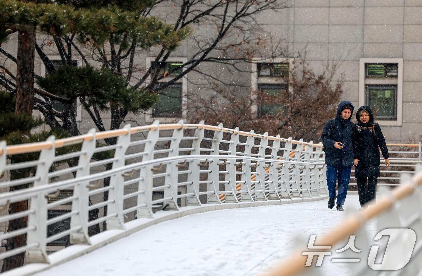 (서울=뉴스1) 이호윤 기자 = 눈이 내리는 12일 서울 마포구 인근 육교에서 외국인 관광객들이 발걸음을 옮기고 있다. 2026.1.12/뉴스1