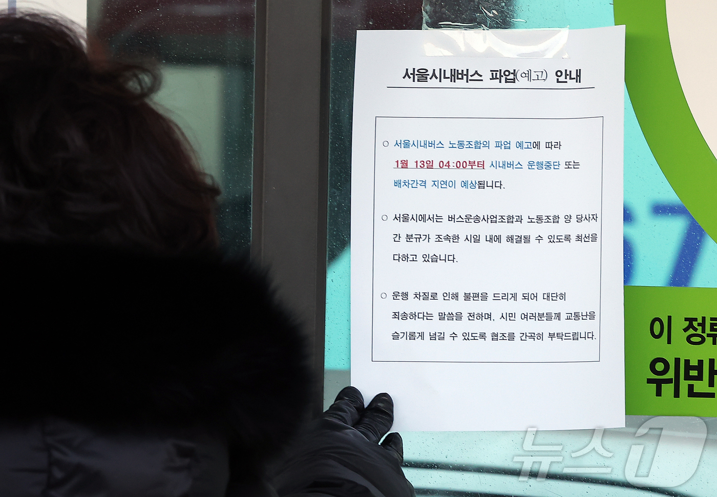 (서울=뉴스1) 김진환 기자 = 서울 시내버스가 총파업에 돌입한 13일 오전 서울역 버스환승센터에서 한 시민이 파업을 알리는 안내문을 살펴보고 있다.서울 시내버스가 파업으로 멈춰 …