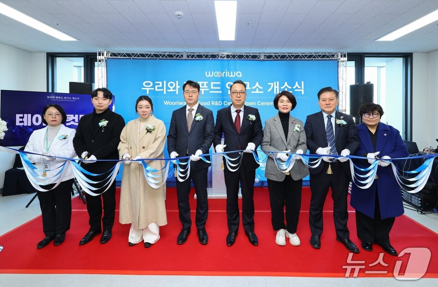본문 이미지 - 왼쪽부터 '2026 우리와 펫푸드 연구소 개소식'에 참석한 김후덕 우리와 연구소장, 이은찬 수대협 회장, 김현유 KK9 대표, 김정욱 농림축산식품부 실장, 최광용 우리와 대표, 한정애 국회의원, 김재영 국경없는 수의사회 대표 등이 테이프 커팅식을 진행하고 있다(우리와주식회사 제공). ⓒ 뉴스1