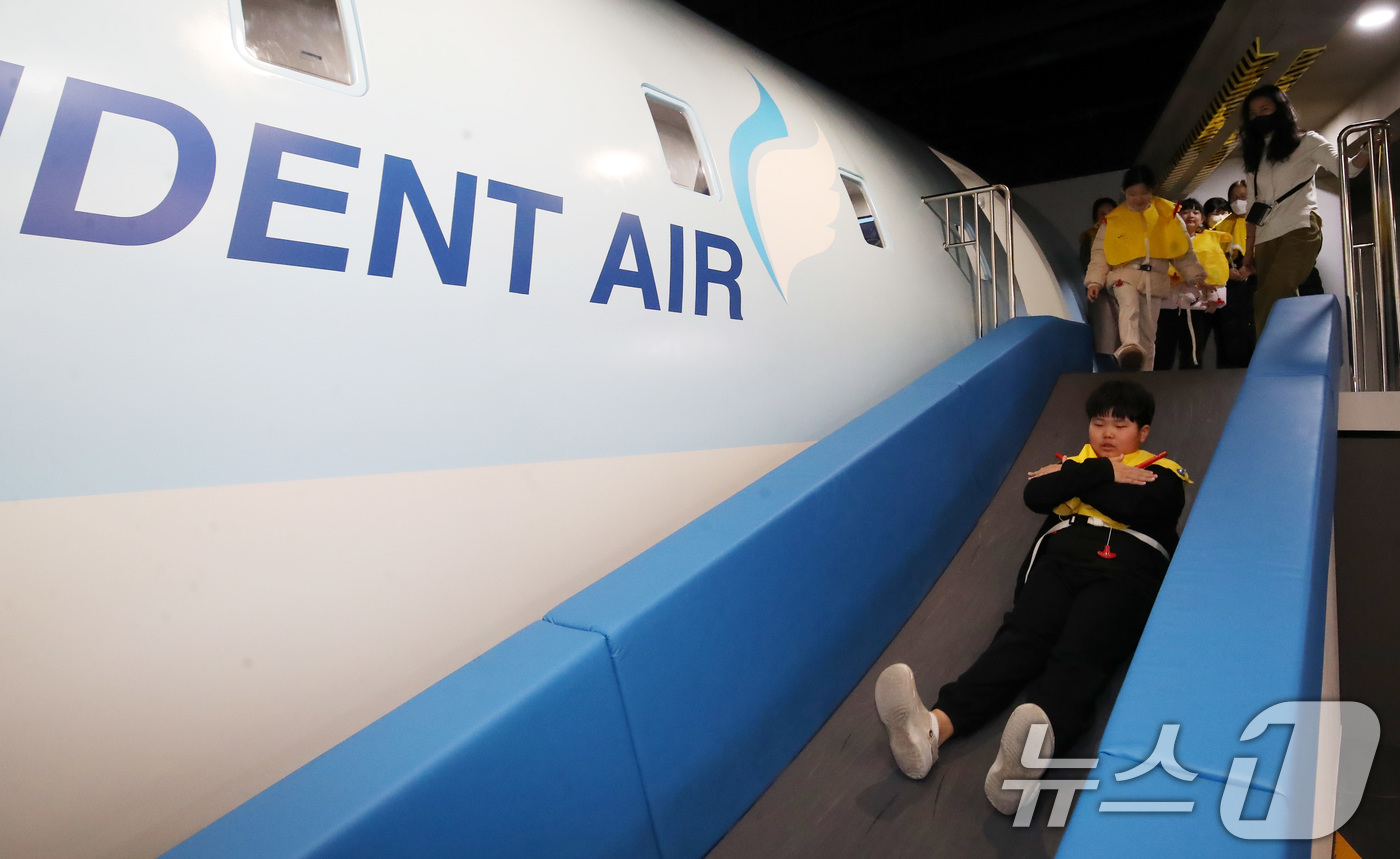 (부산=뉴스1) 윤일지 기자 = 13일 부산 강서구 부산시교육청 학생안전체험관에서 겨울방학을 맞아 '가족·일반인 안전체험'에 참가한 체험객들이 항공기 사고 발생 시 탈출 방법 등을 …