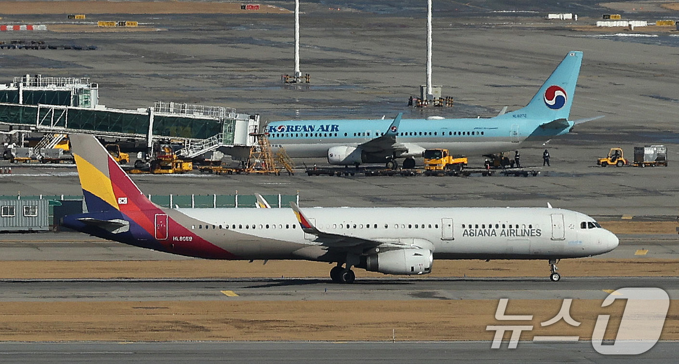 (인천공항=뉴스1) 박지혜 기자 = 13일 인천국제공항 활주로에서 아시아나항공 여객기가 계류장으로 이동하고 있다.기존 인천국제공항 1터미널을 사용하던 아시아나항공은 오는 14일부터 …