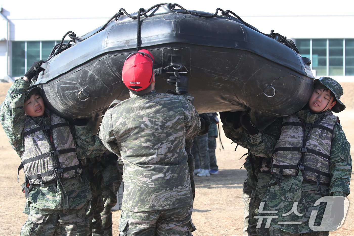 (포항=뉴스1) 공정식 기자 = 13일 경북 포항 해병대 1사단에서 열린 '2026년 겨울 해병대 캠프' 참가자들이 연병장에 IBS(소형고무보트) 도수운반 훈련을 하고 있다.12일 …
