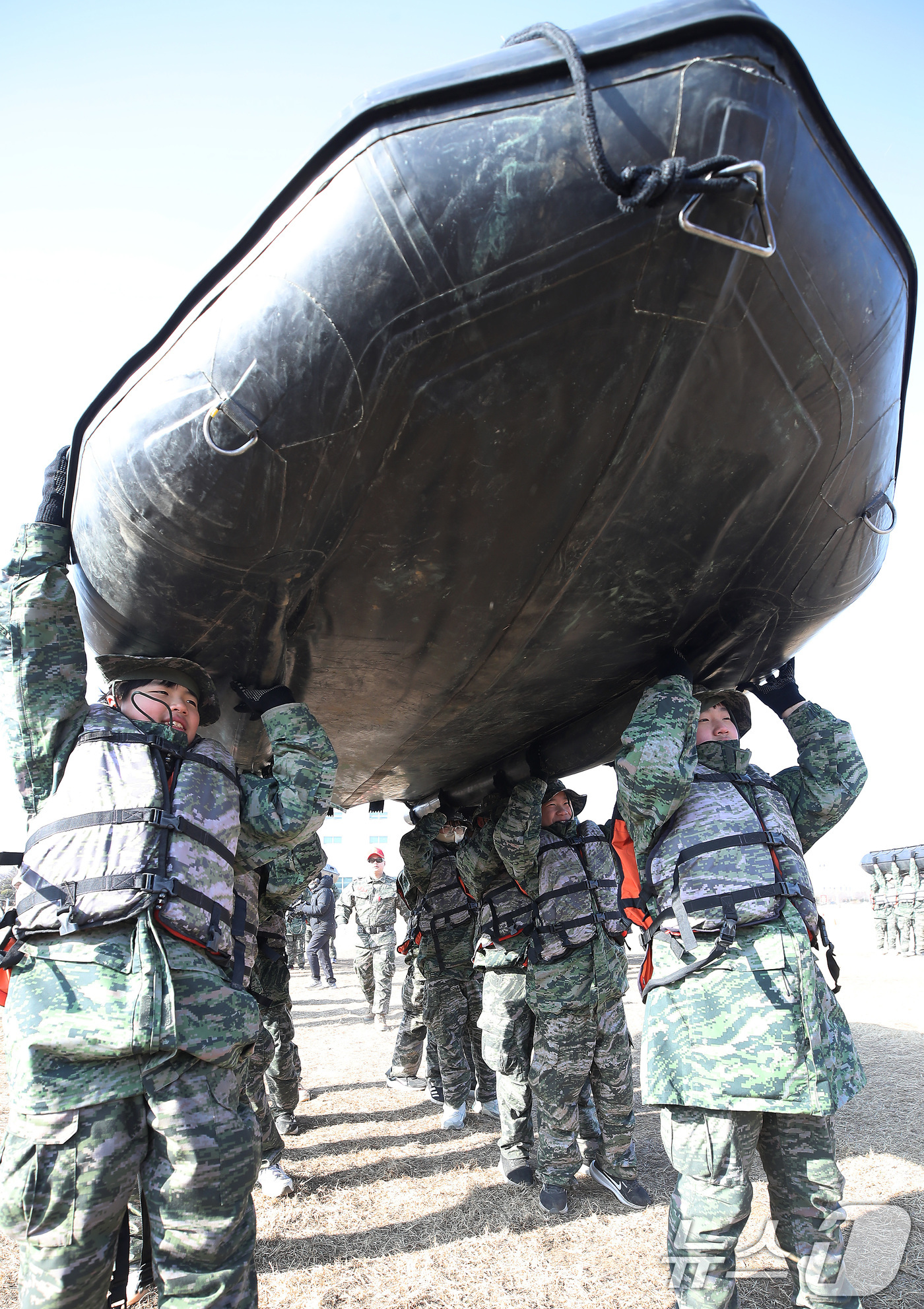 (포항=뉴스1) 공정식 기자 = 13일 경북 포항 해병대 1사단에서 열린 '2026년 겨울 해병대 캠프' 참가자들이 연병장에 IBS(소형고무보트) 도수운반 훈련을 하고 있다.12일 …