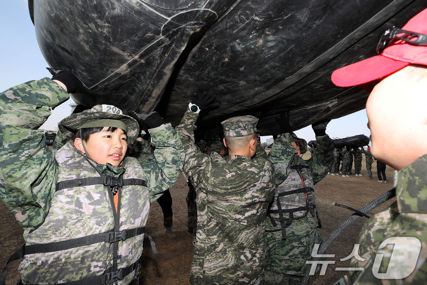(포항=뉴스1) 공정식 기자 = 13일 경북 포항 해병대 1사단에서 열린 '2026년 겨울 해병대 캠프' 참가자들이 연병장에 IBS(소형고무보트) 도수운반 훈련을 하고 있다.12일 …
