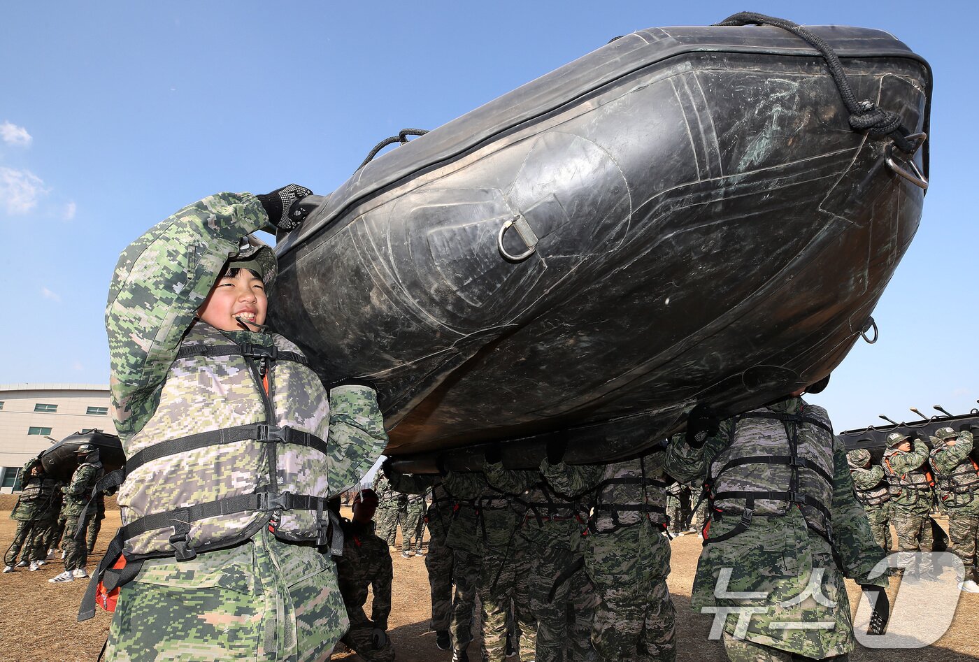 본문 이미지 - 13일 경북 포항 해병대 1사단에서 열린 '2026년 겨울 해병대 캠프' 참가자들이 연병장에 IBS(소형고무보트) 도수운반 훈련을 하고 있다.  2026.1.13/뉴스1 ⓒ News1 공정식 기자