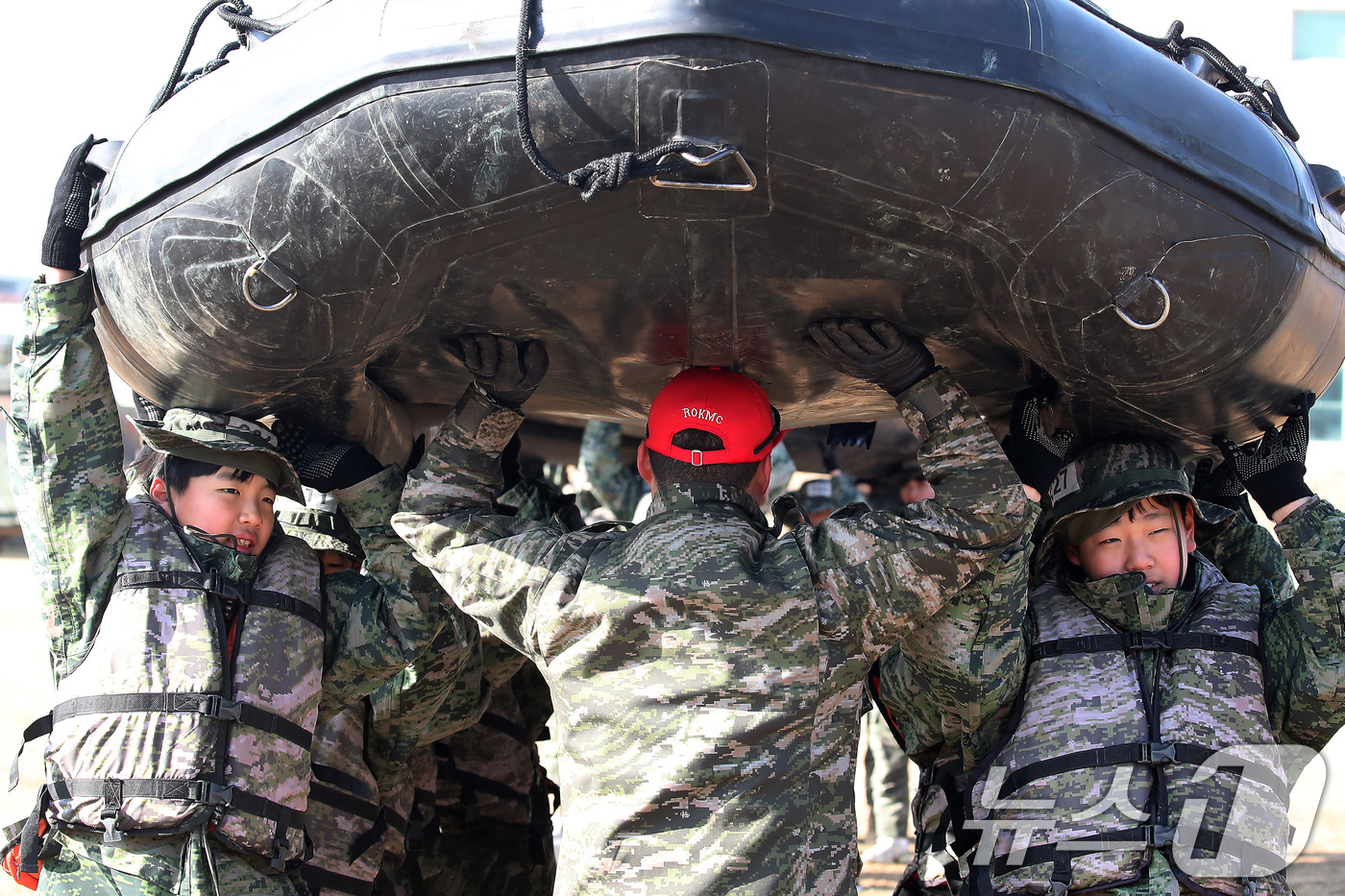 (포항=뉴스1) 공정식 기자 = 13일 경북 포항 해병대 1사단에서 열린 '2026년 겨울 해병대 캠프' 참가자들이 연병장에 IBS(소형고무보트) 도수운반 훈련을 하고 있다.12일 …