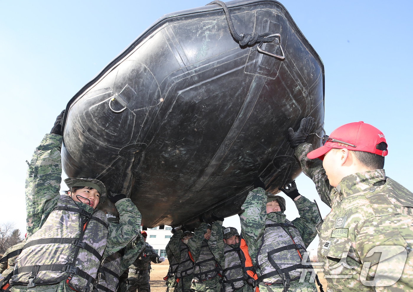 (포항=뉴스1) 공정식 기자 = 13일 경북 포항 해병대 1사단에서 열린 '2026년 겨울 해병대 캠프' 참가자들이 연병장에 IBS(소형고무보트) 도수운반 훈련을 하고 있다.12일 …