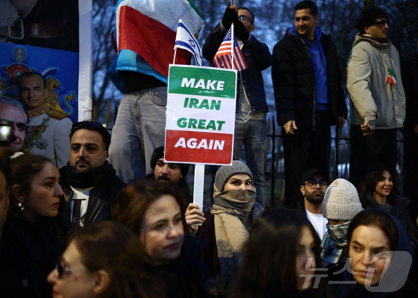 (런던 AFP=뉴스1) 이정환 기자 = 12일(현지시간) 영국 런던 중심부에 위치한 이란 대사관 앞에서 이란 정권 반대 시위대가 이란 국기를 흔들고 있다. 2026.01.12.ⓒ …