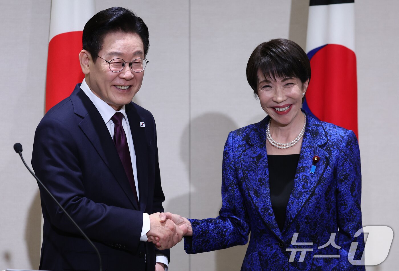 본문 이미지 - 이재명 대통령과 다카이치 사나에 일본 총리가 지난 1월 13일 일본 나라현 회담장에서 공동언론발표를 마친 뒤 악수하고 있다. 2026.1.13 ⓒ 뉴스1 이재명 기자