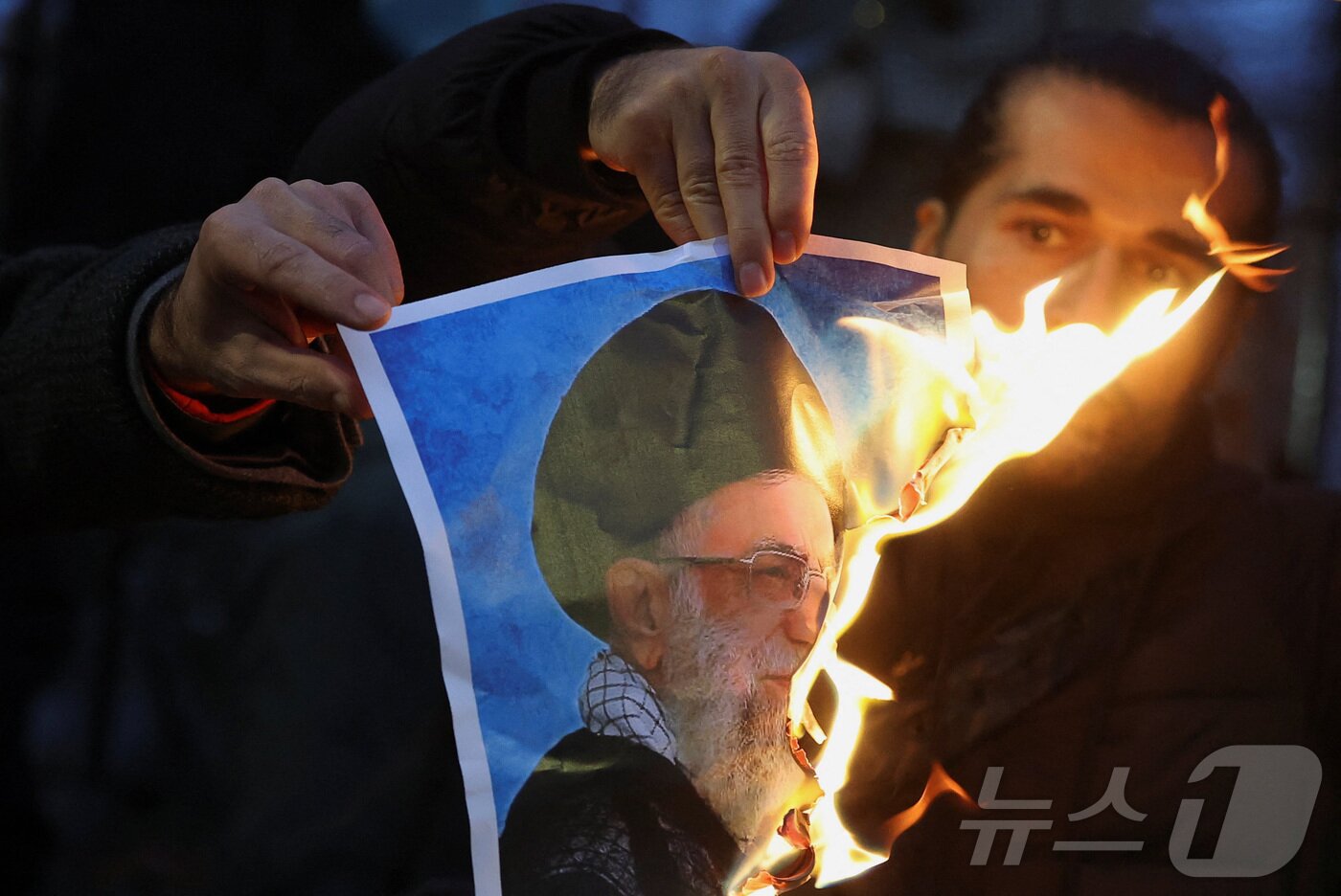 본문 이미지 - 영국 런던에 모인 이란 반정부 시위대가 아야톨라 알리 하메네이 이란 최고지도자의 사진을 불태우고 있다. 2026.01.12 ⓒ 로이터=뉴스1 ⓒ News1 이지예 객원기자