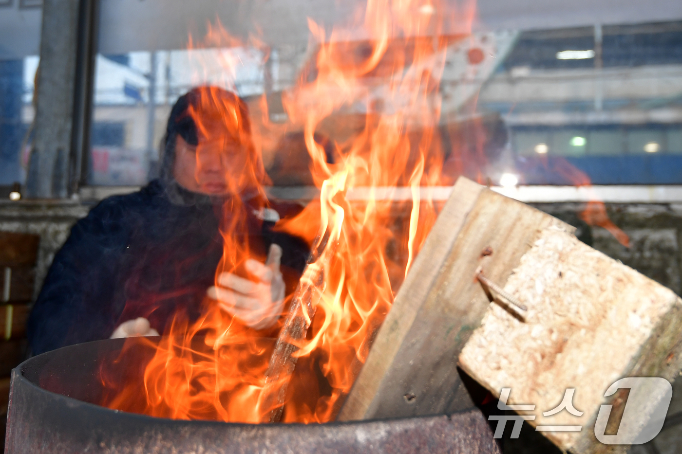 (포항=뉴스1) 최창호 기자 = 중부지역에 한파주의보가 발령된 14일 경북 포항시 북구 죽도어시장에서 상인들이 모닥불에 몸을 녹이고 있다. 2026.1.14/뉴스1