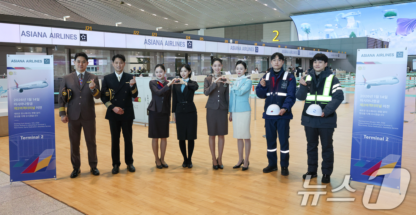 (인천공항=뉴스1) 안은나 기자 = 아시아나항공과 대한항공 운항, 객실, 공항, 정비 임직원들이 14일 인천국제공항 제2터미널에서 아시아나항공 2터미널 이전을 맞아 기념 촬영을 하 …