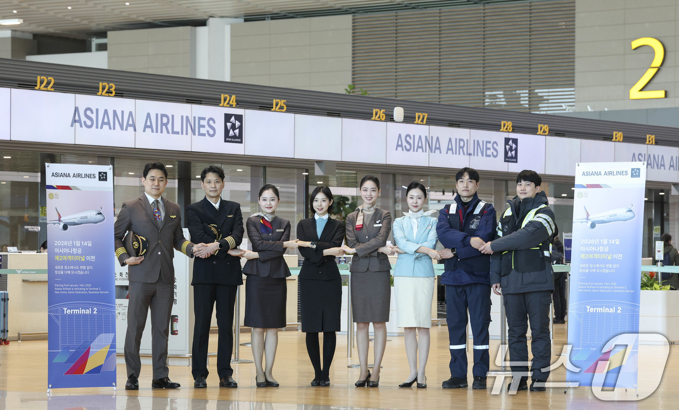 (인천공항=뉴스1) 안은나 기자 = 아시아나항공과 대한항공 운항, 객실, 공항, 정비 임직원들이 14일 인천국제공항 제2터미널에서 아시아나항공 2터미널 이전을 맞아 기념 촬영을 하 …