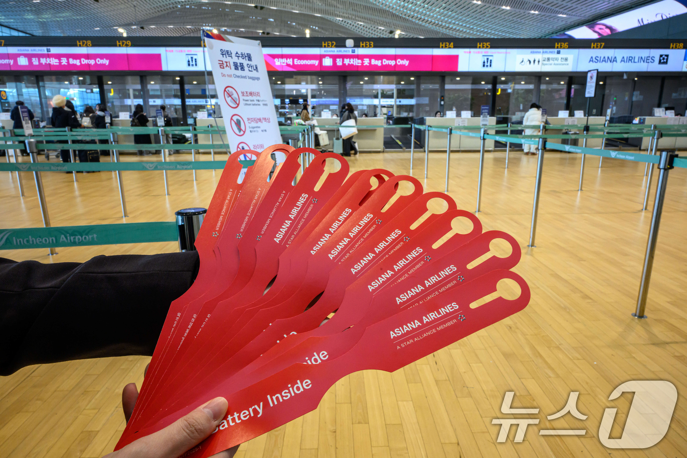 (인천공항=뉴스1) 안은나 기자 = 아시아나항공이 인천공항 제2여객터미널 운항을 개시한 14일 인천국제공항 2터미널 아시아나항공 체크인 카터에서 한 직원이 '노 배터리(NO BAT …