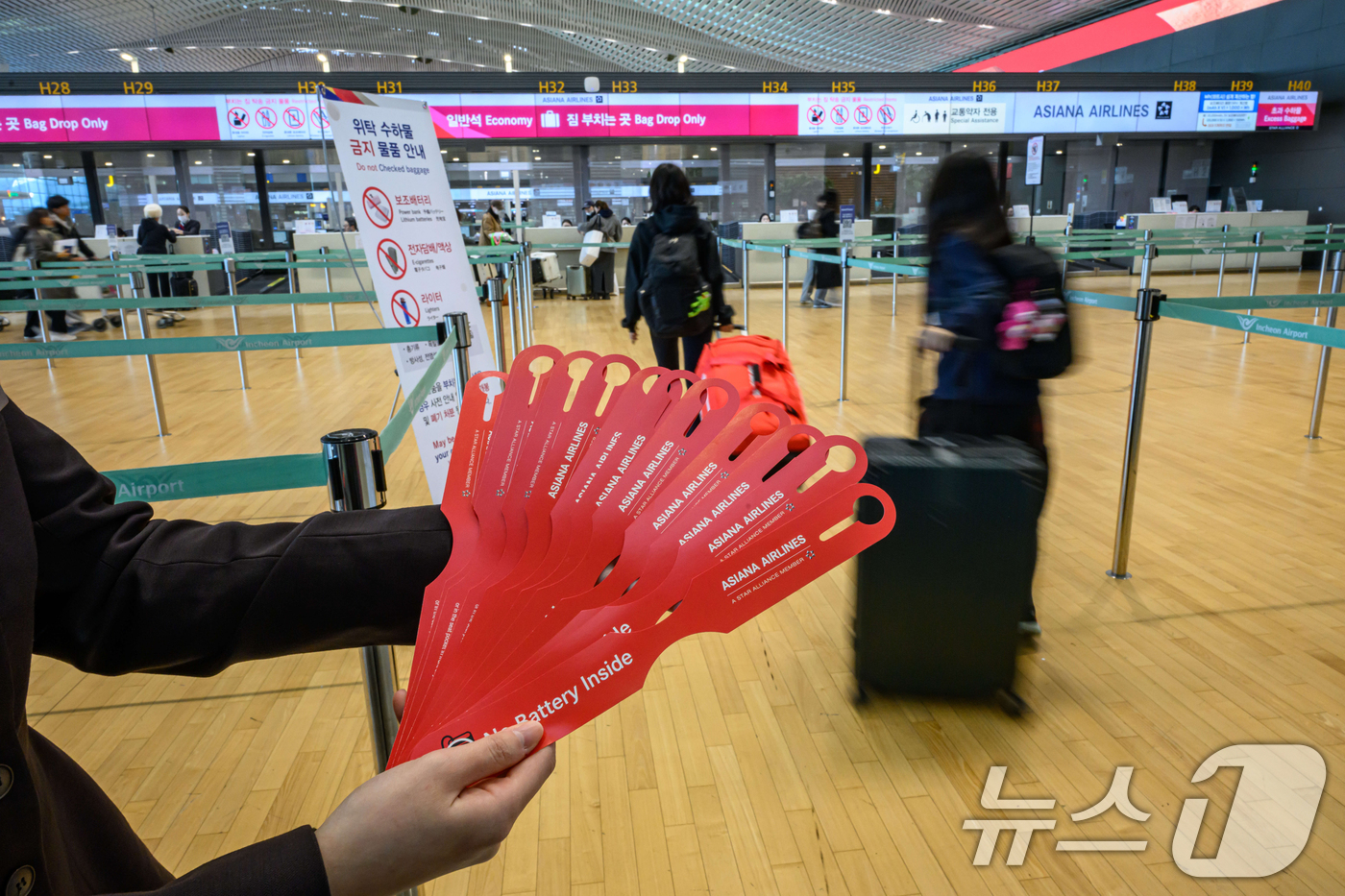 (인천공항=뉴스1) 안은나 기자 = 아시아나항공이 인천공항 제2여객터미널 운항을 개시한 14일 인천국제공항 2터미널 아시아나항공 체크인 카터에서 한 직원이 '노 배터리(NO BAT …