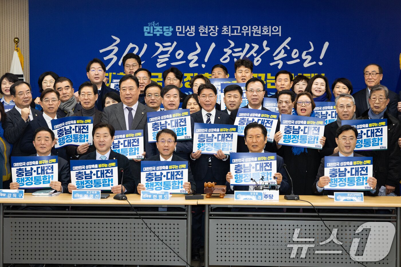 본문 이미지 - 정청래 더불어민주당 대표와 한병도 원내대표를 비롯한 지도부와 참석자들이 14일 충남 서산시 서산축산종합센터에서 열린 충남 민생 현장 최고위원회의에 앞서 '충남·대전 행정통합' 피켓팅 퍼포먼스를 하고 있다. 2026.1.14/뉴스1 ⓒ News1 유승관 기자