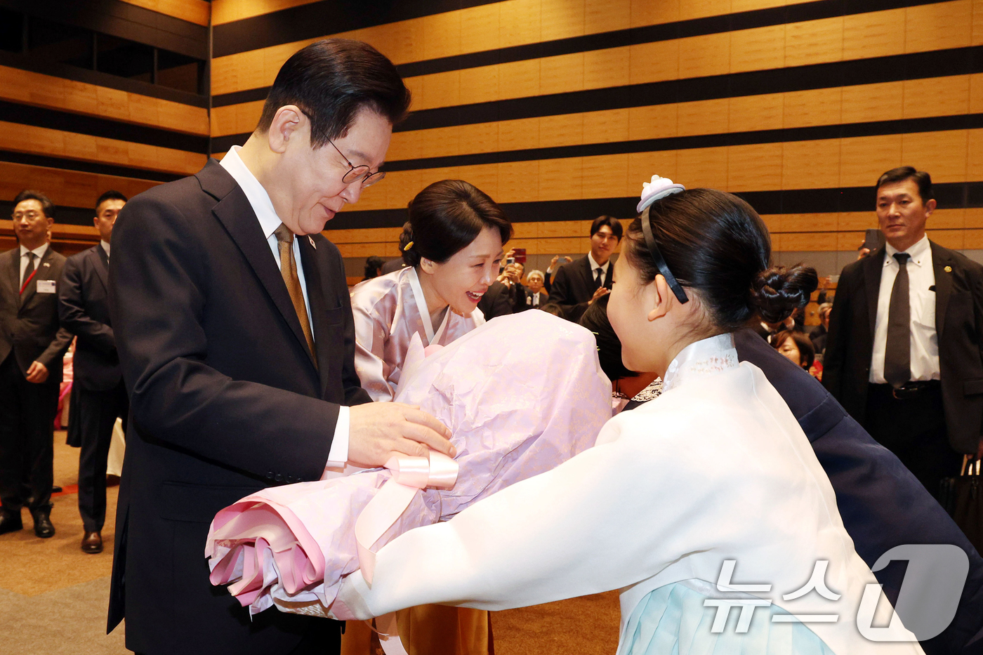 (나라(일본)=뉴스1) 이재명 기자 = 이재명 대통령과 김혜경 여사가 14일 일본 나라현의 한 호텔에서 열린 간사이 동포 간담회에서 화동들에게 꽃다발을 받고 있다. 2026.1.1 …