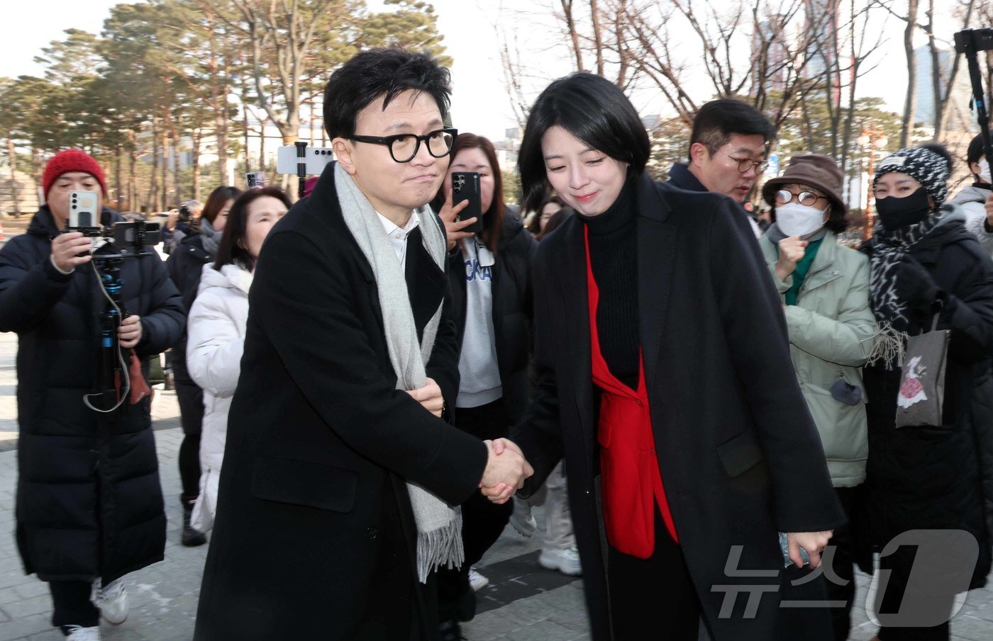 본문 이미지 - 한동훈 전 국민의힘 대표가 지난 14일 당 윤리위원회가 본인을 제명 결정한 것과 관련해 입장을 밝히기 위해 국회 소통관으로 향하며 배현진 국민의힘 의원과 악수를 하고 있다. (공동취재) 2026.1.14/뉴스1 ⓒ News1 신웅수 기자