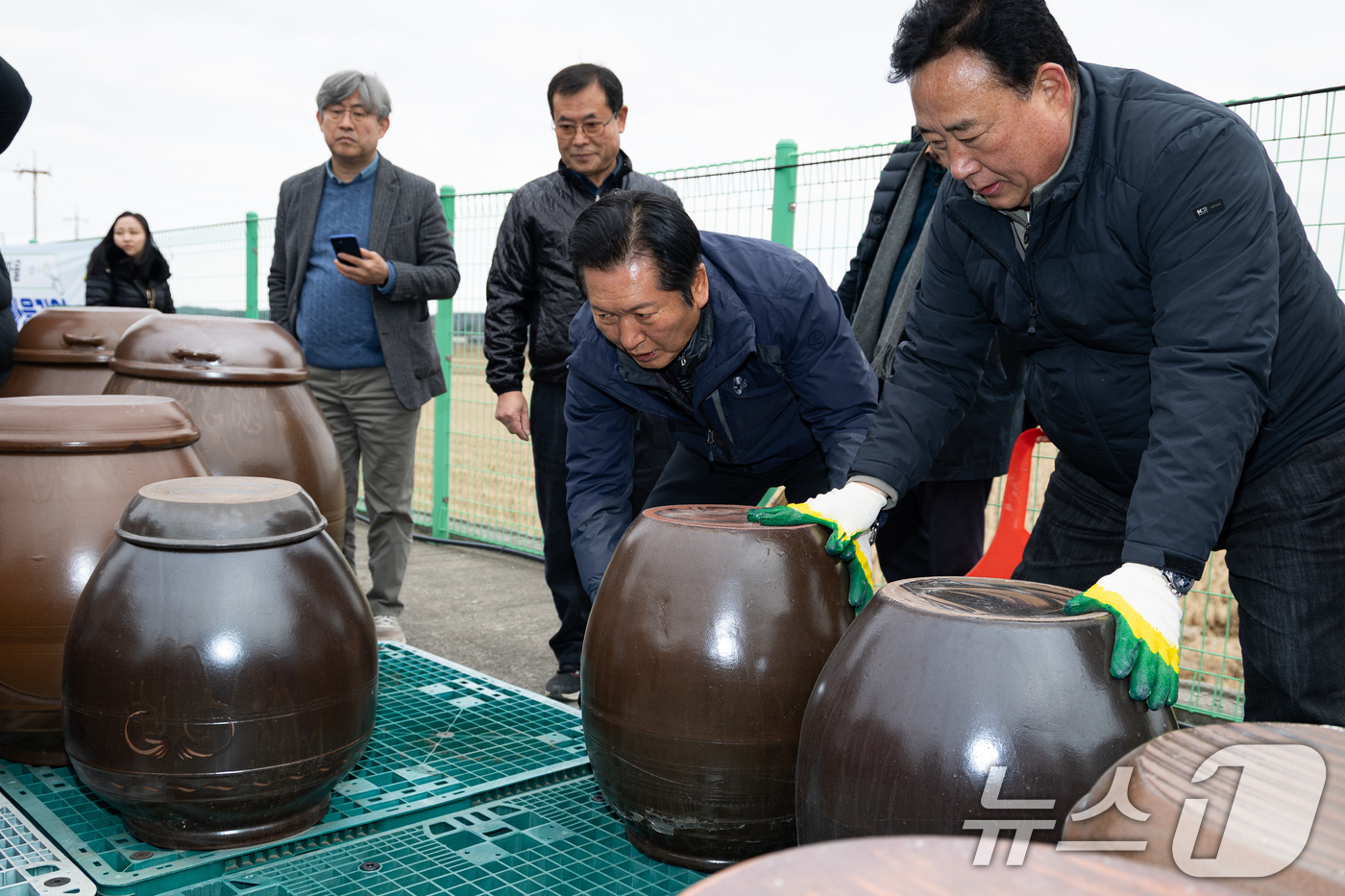 (당진=뉴스1) 유승관 기자 = 정청래 더불어민주당 대표가 14일 충남 당진시 백석올미마을기업을 방문해 장독 옮기기 작업을 하고 있다. 오른쪽은 어기구 농해수위원장. 2026.1. …