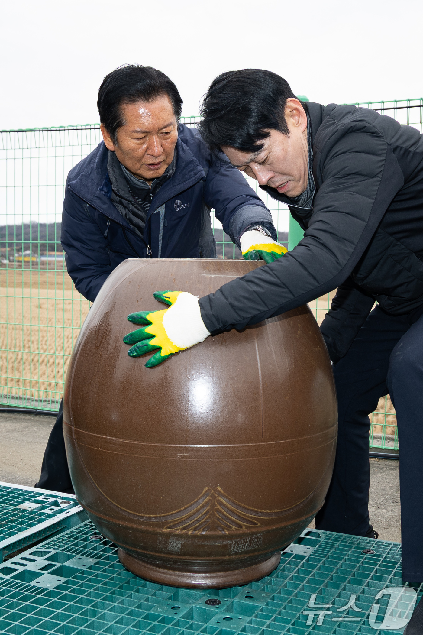(당진=뉴스1) 유승관 기자 = 정청래 더불어민주당 대표가 14일 충남 당진시 백석올미마을기업을 방문해 장독 옮기기 작업을 하고 있다. 오른쪽은 한민수 당대표 비서실장. 2026. …