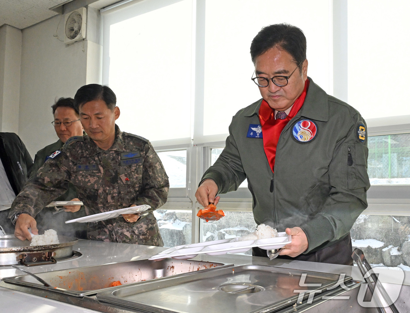 (서울=뉴스1) 국회사진기자단 = 우원식 국회의장이 14일 강원도 원주시 제8전투비행단을 위문 방문, 군장병과 오찬을 하기 위해 배식하고 있다. 2026.1.14/뉴스1