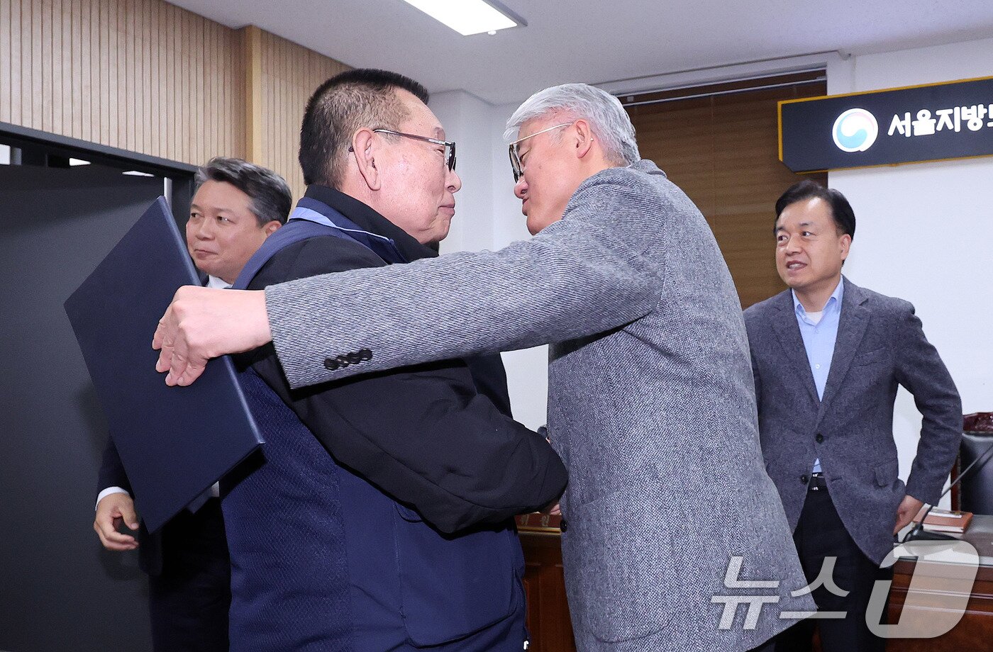 본문 이미지 - 14일 서울 영등포구 서울지방노동위원회에서 열린 특별조정위원회 2차 사후 조정회의에서 서울 시내버스 노사가 임금협상에 극적으로 합의한 뒤 박점곤 서울시버스노동조합 위원장과 김정환 서울시버스사업조합 이사장이 포옹을 하고 있다. 2026.1.15/뉴스1 ⓒ News1 박지혜 기자