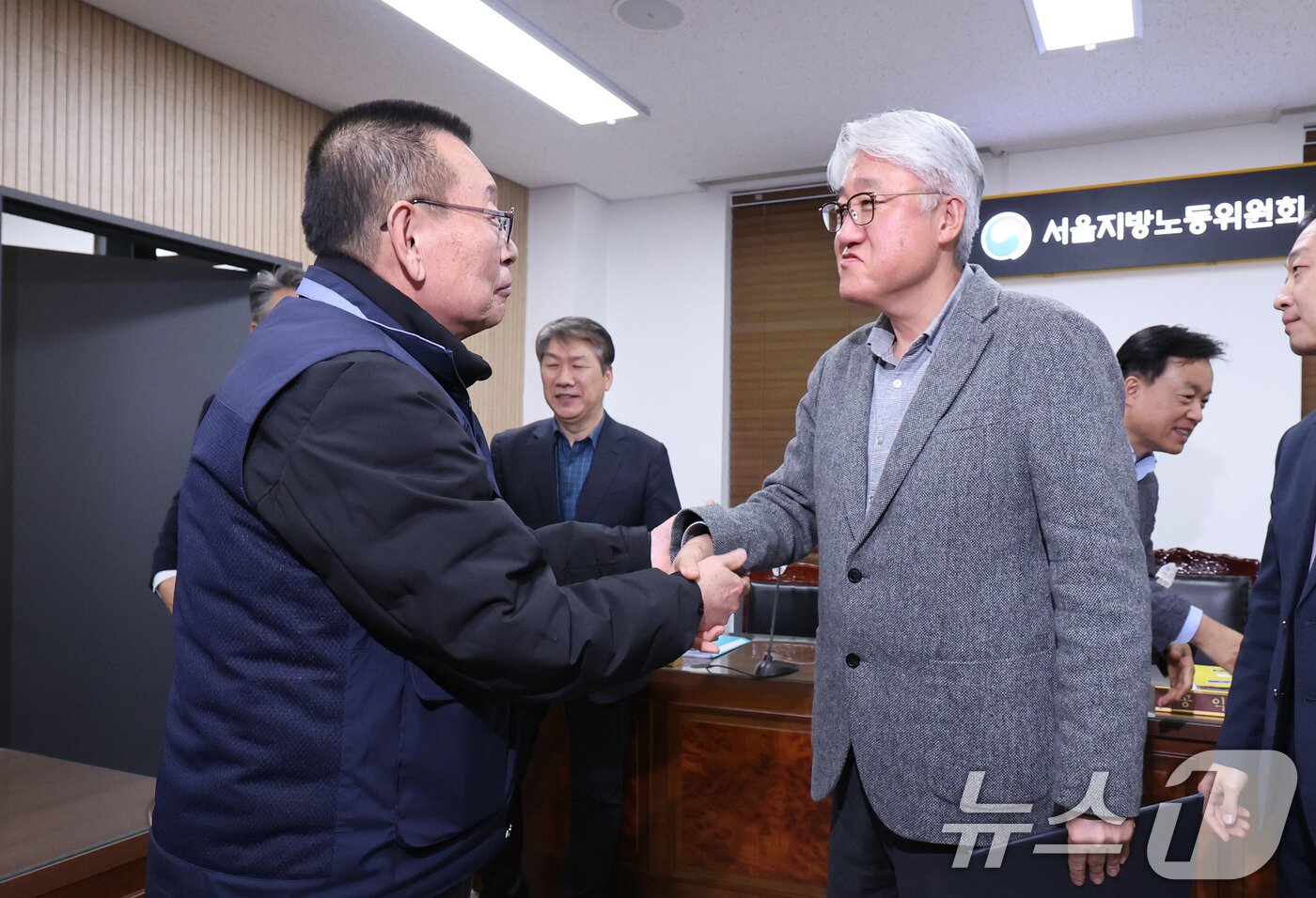 본문 이미지 - 14일 서울 영등포구 서울지방노동위원회에서 열린 특별조정위원회 2차 사후 조정회의에서 서울 시내버스 노사가 임금협상에 극적으로 합의한 뒤 박점곤 서울시버스노동조합 위원장과 김정환 서울시버스사업조합 이사장이 악수를 나누고 있다. 2026.1.15/뉴스1 ⓒ News1 박지혜 기자