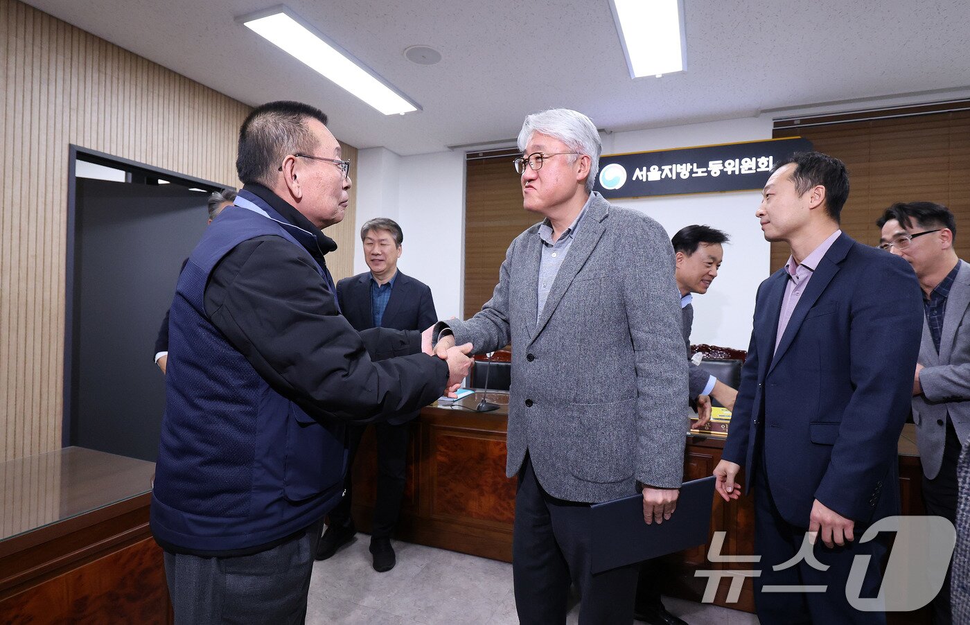 본문 이미지 - 14일 서울 영등포구 서울지방노동위원회에서 열린 특별조정위원회 2차 사후 조정회의에서 서울 시내버스 노사가 임금협상에 극적으로 합의한 뒤 박점곤 서울시버스노동조합 위원장과 김정환 서울시버스사업조합 이사장이 악수를 하고 있다. 2026.1.15/뉴스1 ⓒ News1 박지혜 기자