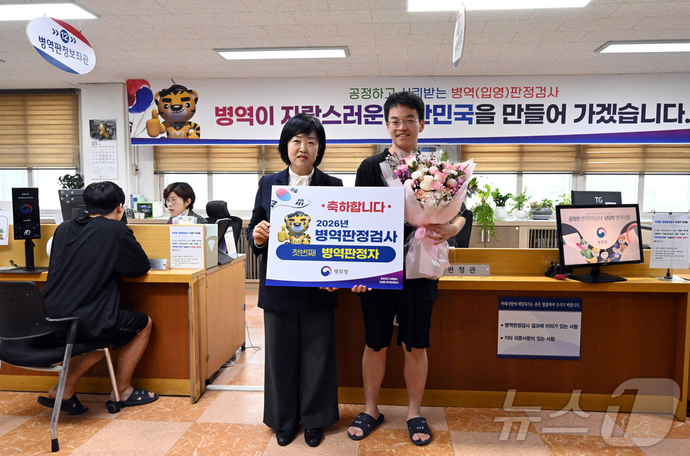 (서울=뉴스1) 김명섭 기자 = 15일 서울 영등포구 서울지방병무청에서 2026년 첫 현역 대상 판정자가 홍소영 병무청장에게 축하받고 있다. (공동취재) 2026.1.15/뉴스1