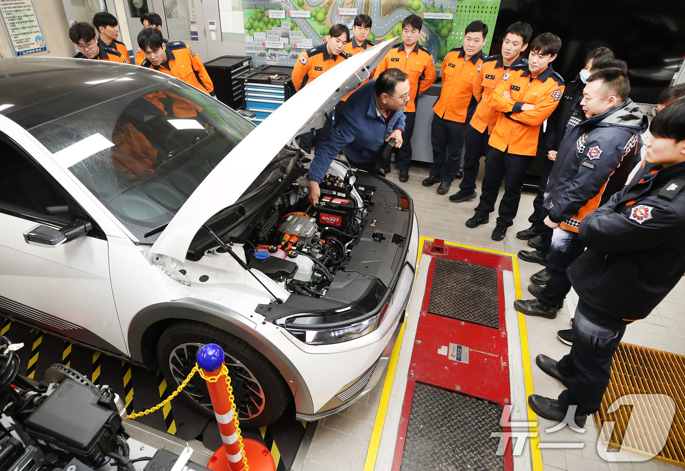 (대구=뉴스1) 공정식 기자 = 15일 대구 남구 영남이공대 스마트 e-자동차과 실습실에서 열린 '대구소방안전본부 전기자동차 화재진압 역량 강화 교육'에 참가한 소방관들이 전기차를 …