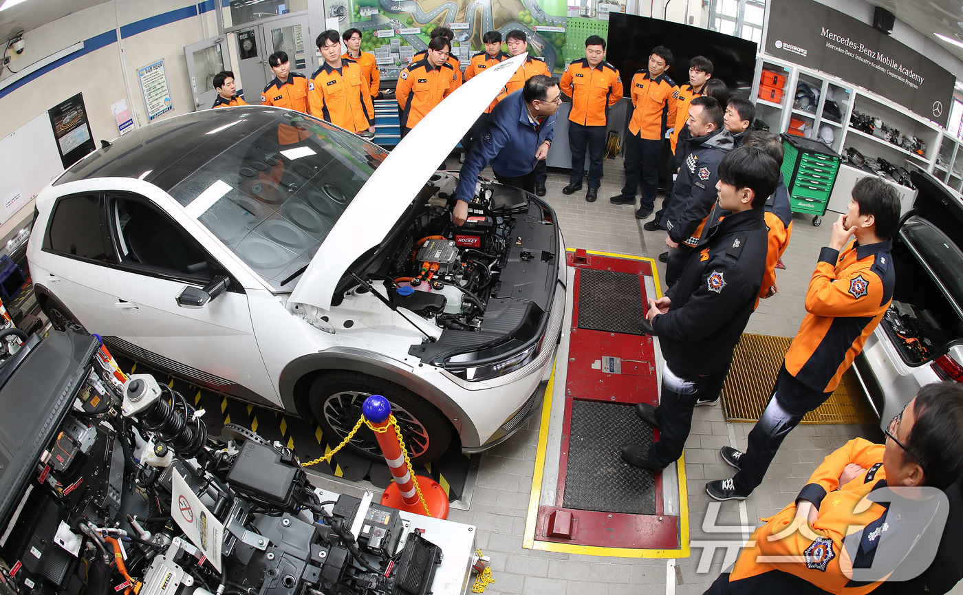 (대구=뉴스1) 공정식 기자 = 15일 대구 남구 영남이공대 스마트 e-자동차과 실습실에서 열린 '대구소방안전본부 전기자동차 화재진압 역량 강화 교육'에 참가한 소방관들이 전기차를 …